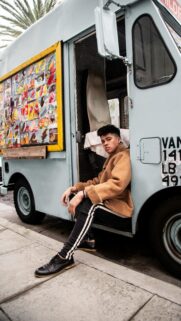 Stylish Young Man Sitting in Vintage Ice Cream Truck Wallpaper