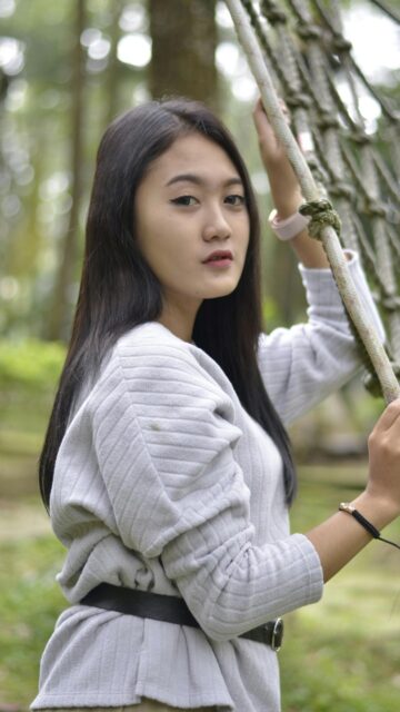 Asian Girl Holding Rope Net in Forest Nature Aesthetic Phone Wallpaper