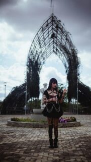 Gothic Girl With Book Under Metal Archway Mobile Wallpaper