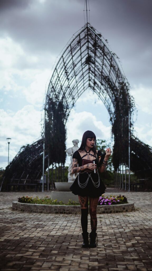 Gothic Girl With Book Under Metal Archway Mobile Wallpaper