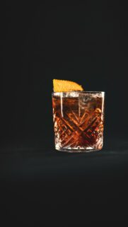 Elegant Whiskey Old Fashioned Cocktail with Orange Garnish Mobile Wallpaper