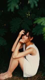 Beautiful Asian Girl Sitting in Nature Garden Mobile Phone Wallpaper
