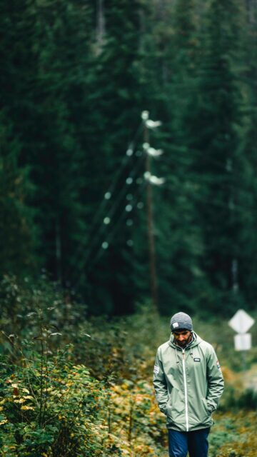 Man Walking in Moody Forest Trail Adventure Mobile Wallpaper