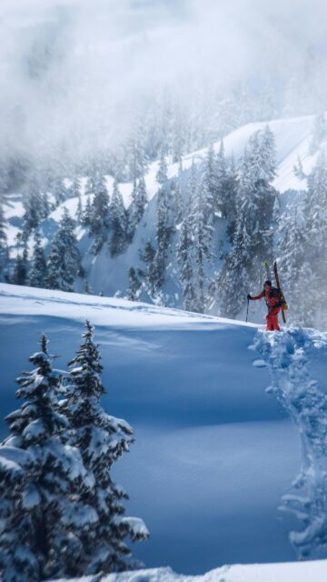 Adventurous Backcountry Skier in Snowy Mountain Wilderness Wallpaper