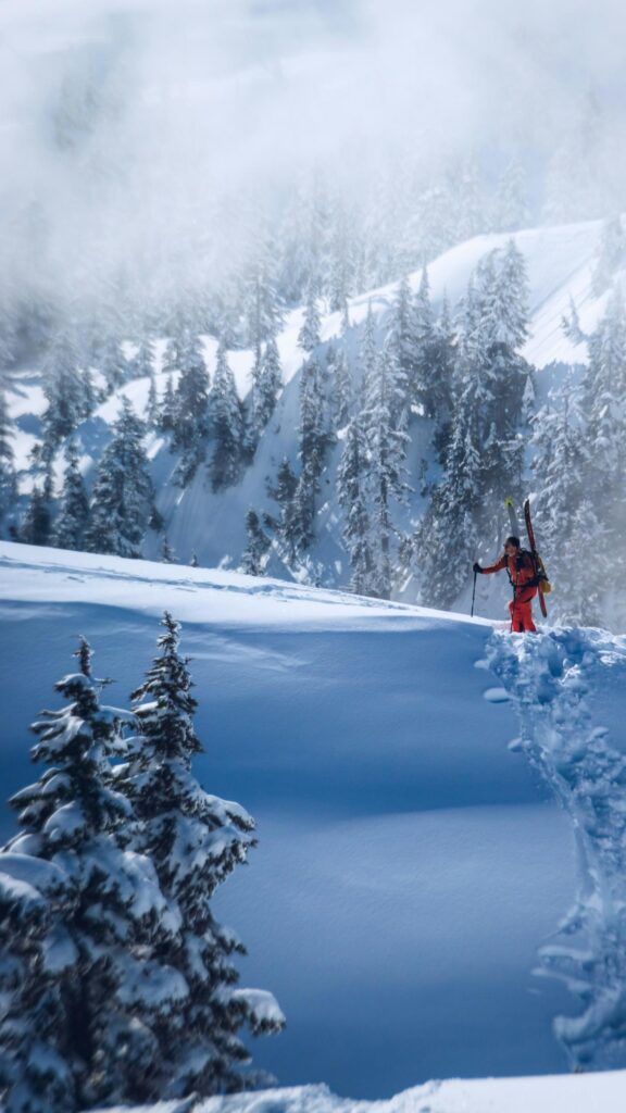 Adventurous Backcountry Skier in Snowy Mountain Wilderness Wallpaper