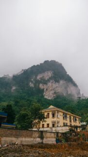 Misty Limestone Mountain and Colonial Villa Architecture Wallpaper