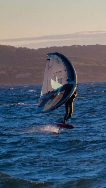 Thrilling Wing Foiling Action at Sunset Mobile Phone Wallpaper