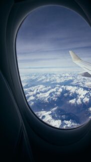 Breathtaking Aerial View of Snow Capped Mountain Peaks Airplane Window Wallpaper