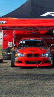 Red BMW E46 Drift Car Under Race Tent Phone Wallpaper