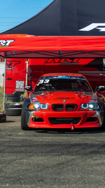 Red BMW E46 Drift Car Under Race Tent Phone Wallpaper