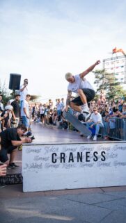 Skater Performing an Intense Mid-Air Trick at an Outdoor Event Wallpaper