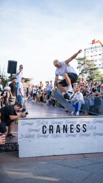 Skater Performing an Intense Mid-Air Trick at an Outdoor Event Wallpaper