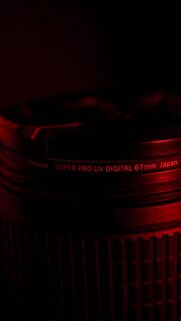 Close-Up Macro Photography of a 67mm Camera Lens in Red Light Wallpaper