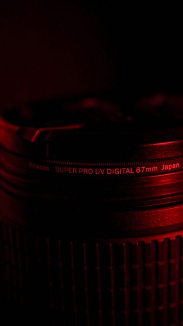 Close-Up Macro Photography of a 67mm Camera Lens in Red Light Wallpaper
