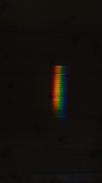 Minimalist Rainbow Light Beam on Dark Wood Texture Mobile Wallpaper