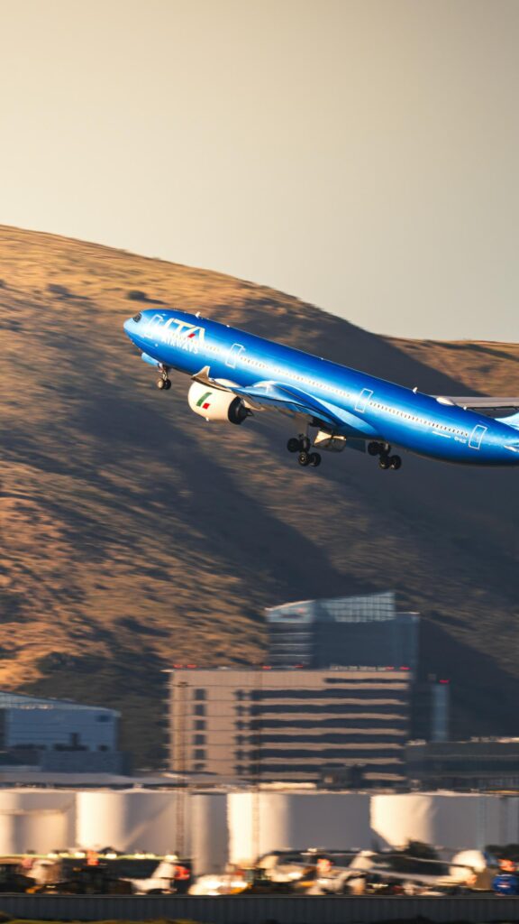 ITA Airways Plane Taking Off Over Mountains Phone Wallpaper