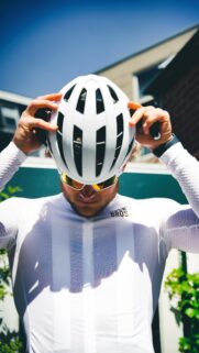 Cyclist Putting on Helmet Sporty White Jersey 4K Mobile Wallpaper