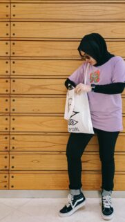 Stylish Woman in Lilac Tee and Hijab against Wooden Background Wallpaper