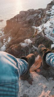 POV Feet Over Santorini Cliff Sunset Mobile Wallpaper