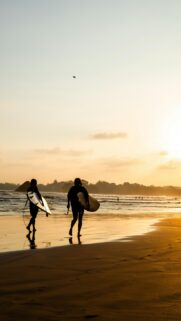 Golden Sunset Surfers Walking on Beach Mobile Phone Wallpaper