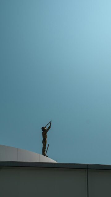Minimalist Golden Statue Looking Up at Clear Blue Sky Mobile Wallpaper