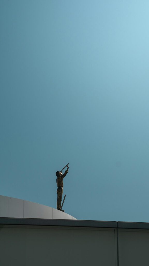 Minimalist Golden Statue Looking Up at Clear Blue Sky Mobile Wallpaper