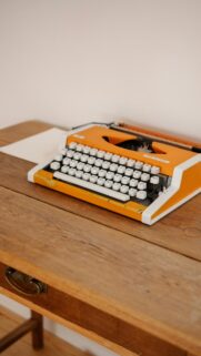 Vintage Orange Typewriter on Wooden Desk Aesthetic Phone Wallpaper