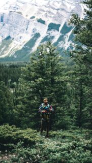 Adventurous Hiker in Rocky Mountain Forest Mobile Wallpaper