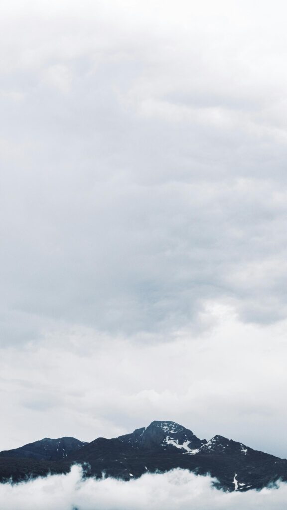 Majestic Snowy Mountain Peak Above Low Clouds Phone Wallpaper