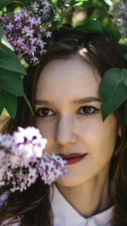Beautiful Woman Surrounded by Purple Lilac Flowers Phone Wallpaper