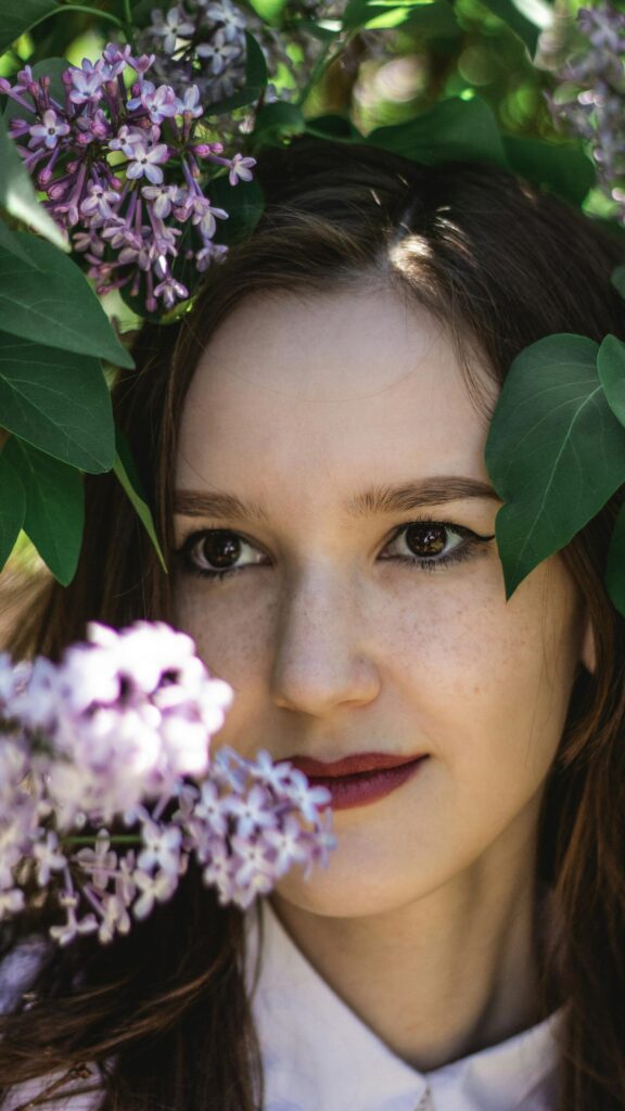 Beautiful Woman Surrounded by Purple Lilac Flowers Phone Wallpaper