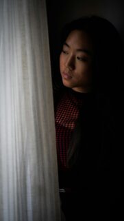 Thoughtful Woman Looking Through Curtains Dark Moody Mobile Wallpaper