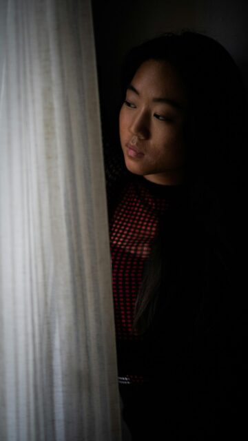 Thoughtful Woman Looking Through Curtains Dark Moody Mobile Wallpaper