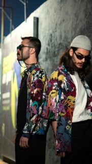 Stylish Duo in Artistic Patterned Shirts Portrait Wallpaper