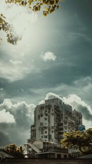 Dramatic Skyscraper Under Moody Storm Clouds Mobile Wallpaper
