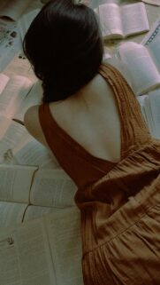 Aesthetic Woman Lying on Books Moody Dark Academia Phone Wallpaper