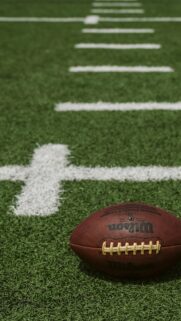 American Football on Turf Field Macro Shot Mobile Wallpaper