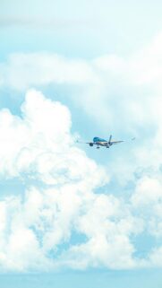 Airliner Flying Through Fluffy White Clouds Minimalist Mobile Wallpaper