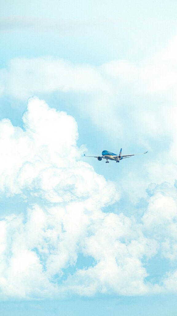 Airliner Flying Through Fluffy White Clouds Minimalist Mobile Wallpaper