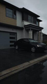 Sleek Black Volkswagen Sedan Parked Outside Modern Home Wallpaper