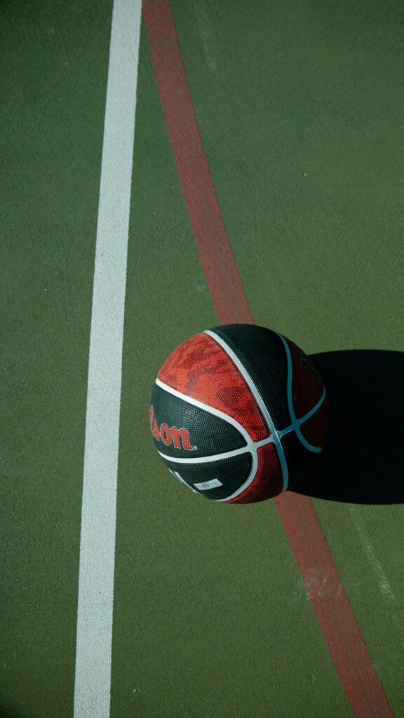 Minimalist Wilson Basketball on Green Court Mobile Wallpaper