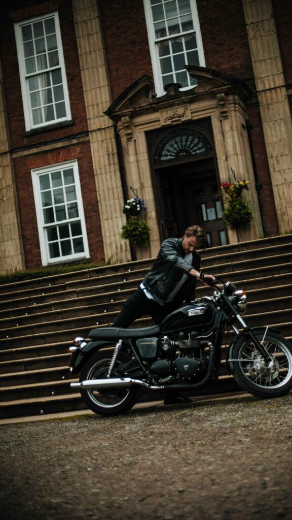 Rugged Biker and Vintage Triumph Motorcycle Elegant Mansion Wallpaper