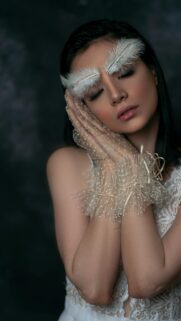 Ethereal Woman with Feather Eyebrows and Lace Gloves Mobile Wallpaper