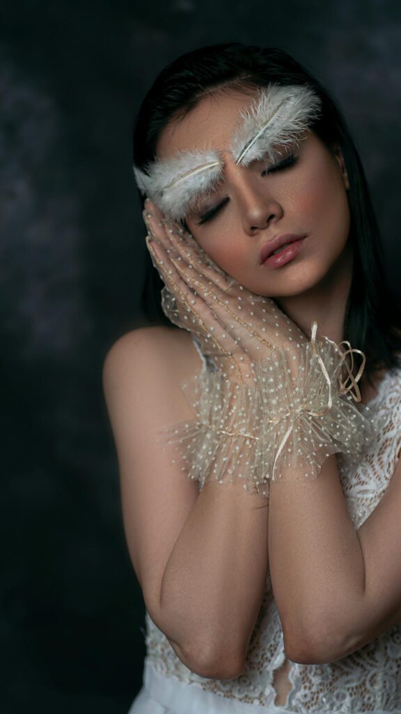 Ethereal Woman with Feather Eyebrows and Lace Gloves Mobile Wallpaper