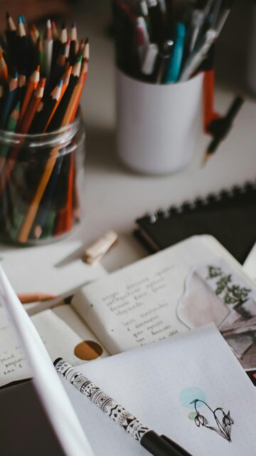 Cozy Artist Desk with Colored Pencils and Journal Aesthetic Wallpaper