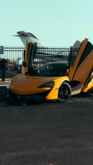 Bright Yellow McLaren Sports Car Airport Runway Mobile Wallpaper