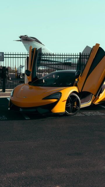 Bright Yellow McLaren Sports Car Airport Runway Mobile Wallpaper