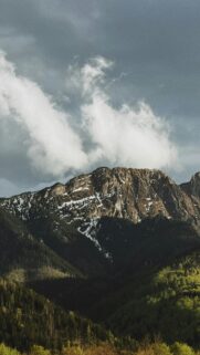 Majestic Snowy Mountain Peak Under Stormy Clouds Mobile Wallpaper