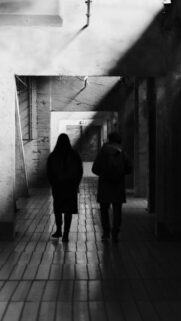 Two Silhouettes Walking Through Dark Moody Hallway Mobile Wallpaper