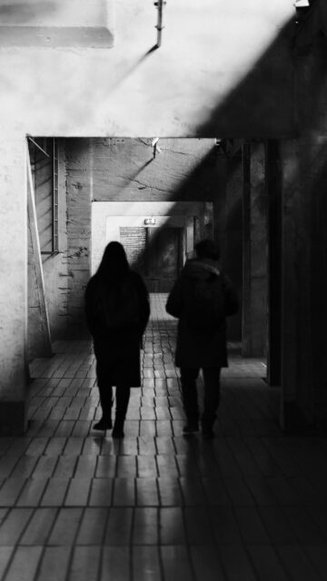 Two Silhouettes Walking Through Dark Moody Hallway Mobile Wallpaper